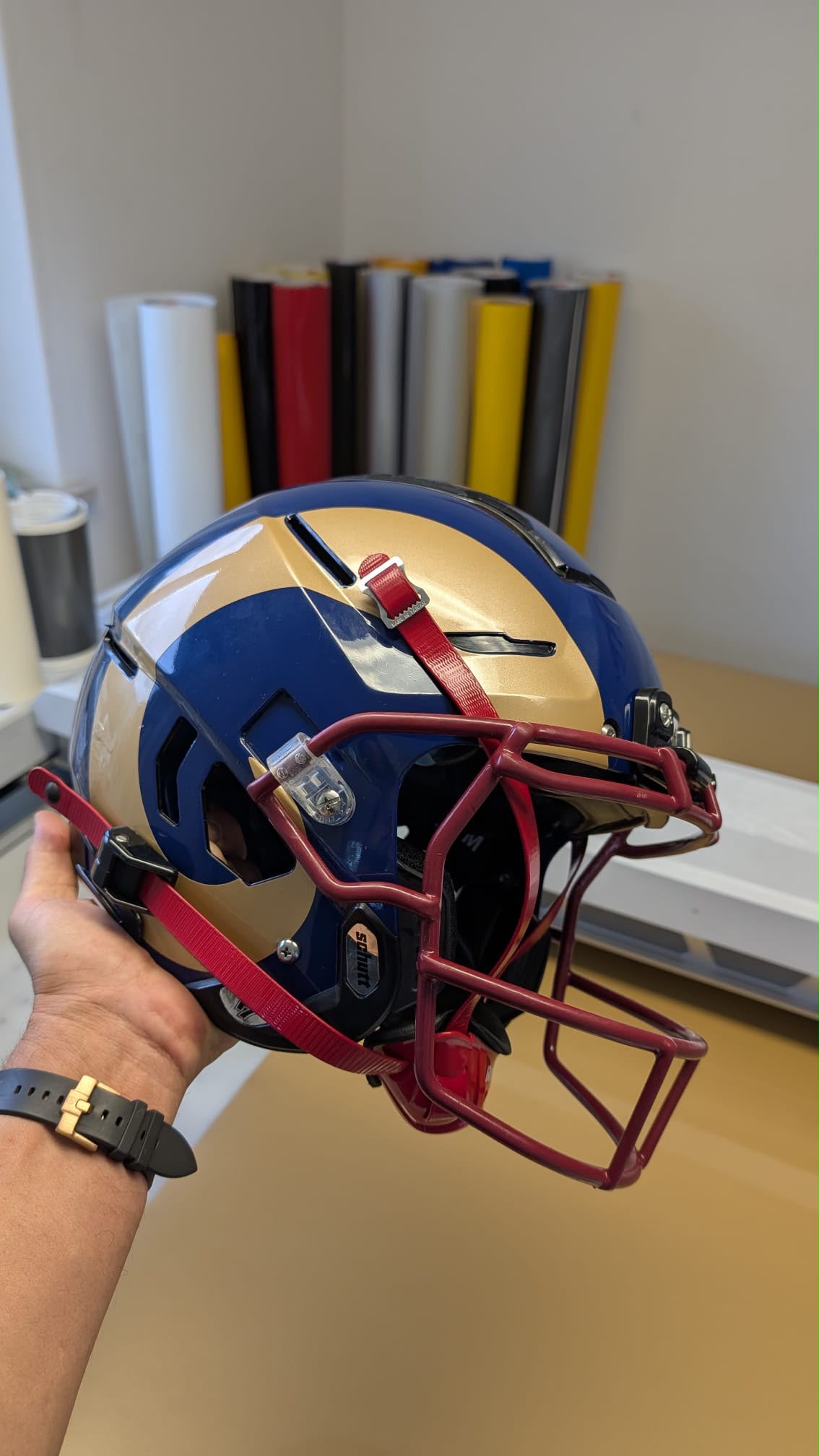 Blau-gold folierter American-Football-Helm mit rotem Gesichtsgitter