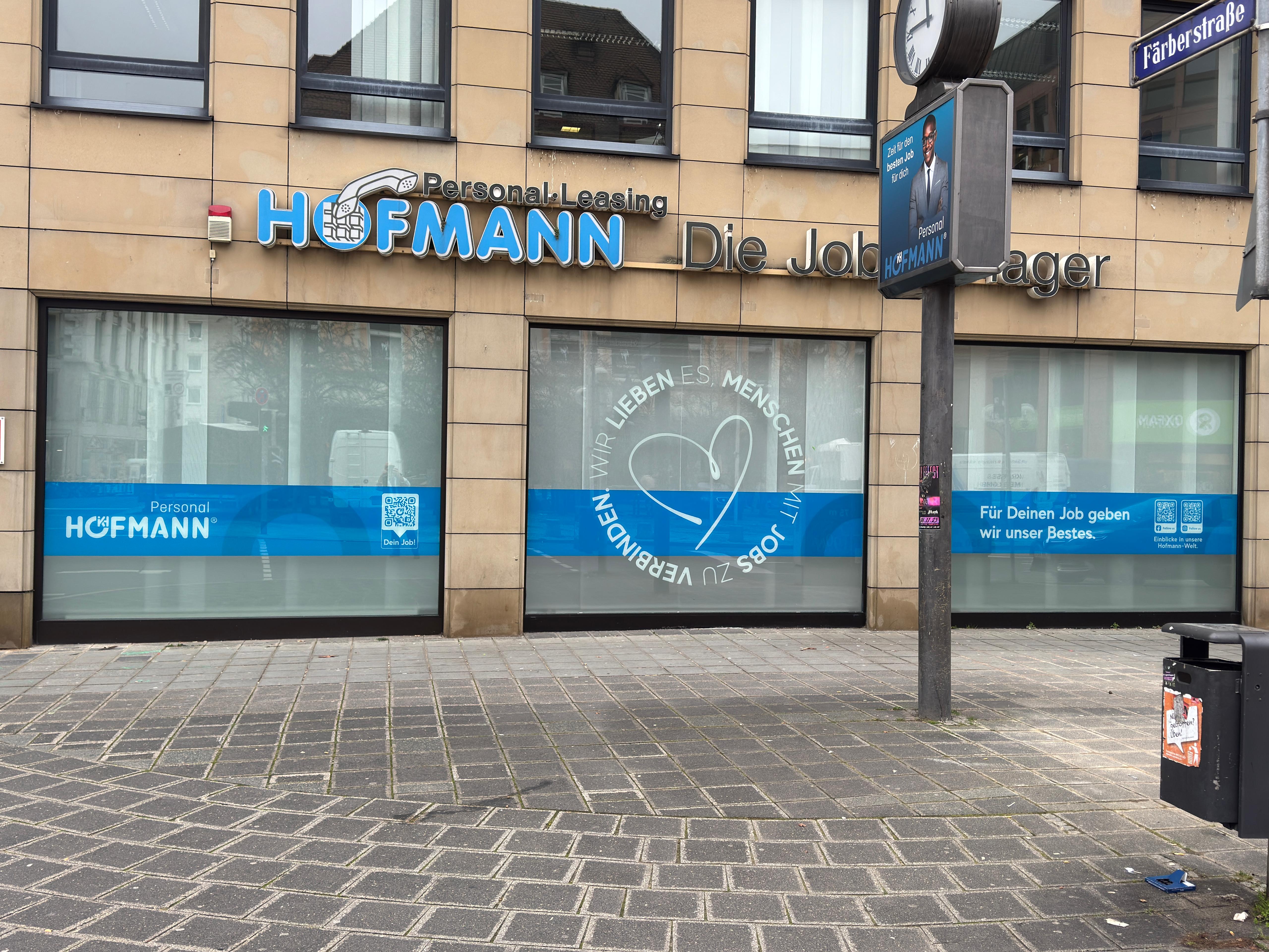Schaufensterfolierung für Hofmann Personal-Leasing mit blauen Markenflächen und Werbebotschaft